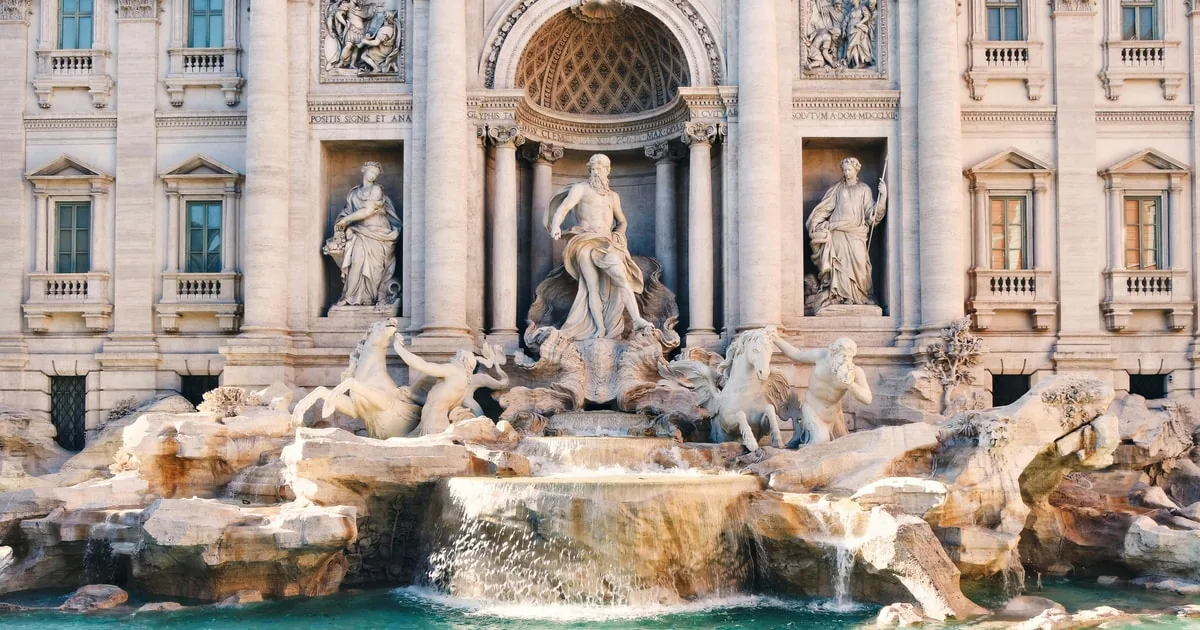 Close view of the Trevi Fountain's central niche with the statue of Oceanus, tritons and sea horses above water cascading over carved rocks into the basin
